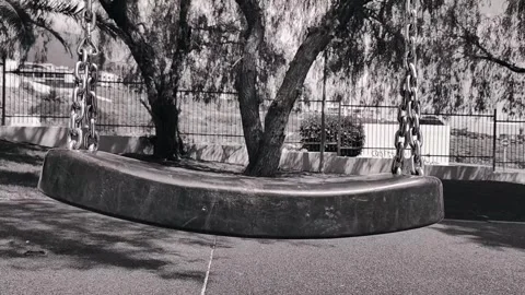 Close Up Empty Playground Swing Swaying Black and White Stock Footage 335887541