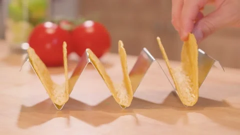 Close-up of an empty stainless steel taco stand as a hand adds 3 corn taco Stock Footage 309001797