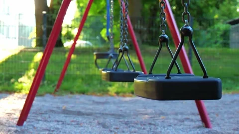 Close up of empty swing moving slowly during sunny day at park Stock Footage 314875543
