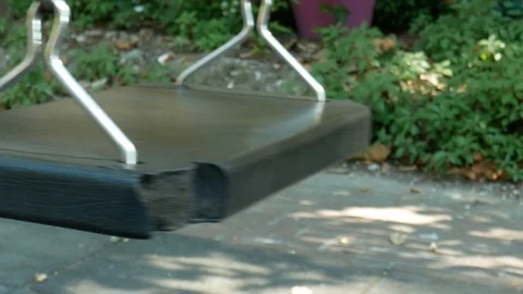 Close-up of empty swing seat swaying in slow motion Vídeos de archivo 128703622