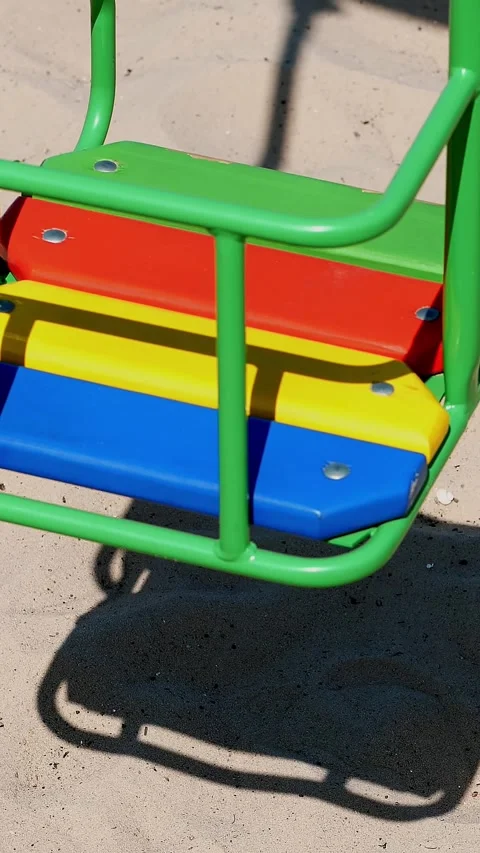 Close-up, empty swing sways on the beach, casts a shadow, on a hot summer day Stock Footage 318681847
