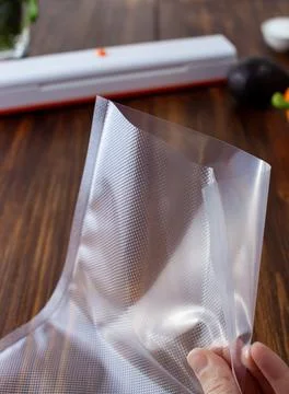 Close-up of an empty vacuum bag with different textures in a woman's hand Stock Photos