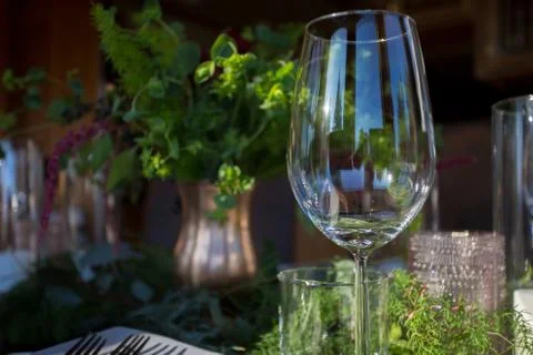 Close up of empty wine glass on a table decorated with fresh flowers. Stock Photos