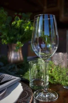 Close up of empty wine glass on a table decorated with fresh flowers. Stock Photos
