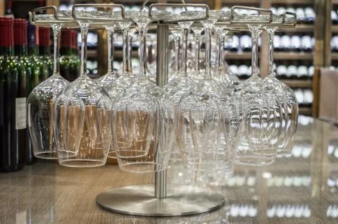 Close up empty wine glasses hanging upside down in a wine store Stock Photos