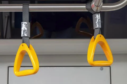 Close-up of an empty yellow handrail or handles for passenger in metro. Stock Photos