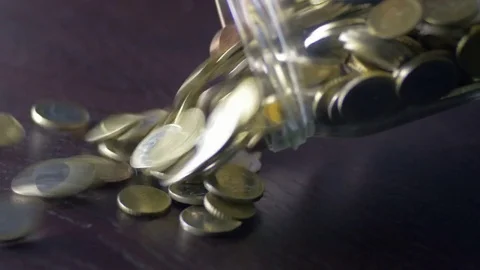 Close-up of emptying a jar full of collected coins on a desk Stock-Footage 74507975