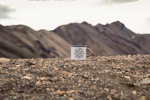 Close up enamel mug on pebble concept photo Stock Photos