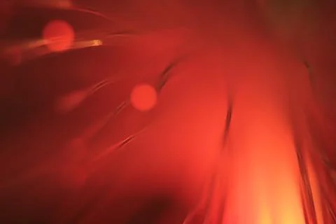 Close up on the ends of a selection of illuminated red fiber optic light stra Stock Photos