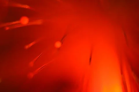 Close up on the ends of a selection of illuminated red fiber optic light stra Stock Photos