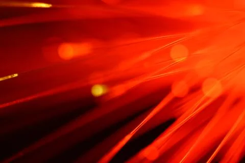Close up on the ends of a selection of illuminated red fiber optic light stra Stock Photos