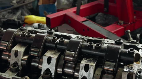 Close-up of engine camshaft assembly with rocker arms and metal components in Stock Footage 345765224