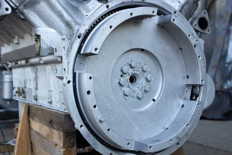 Close-up of the engine flywheel and part of the engine block mounted on woode Stock Photos
