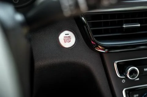 Close-up of engine start stop button on car dashboard Stock Photos