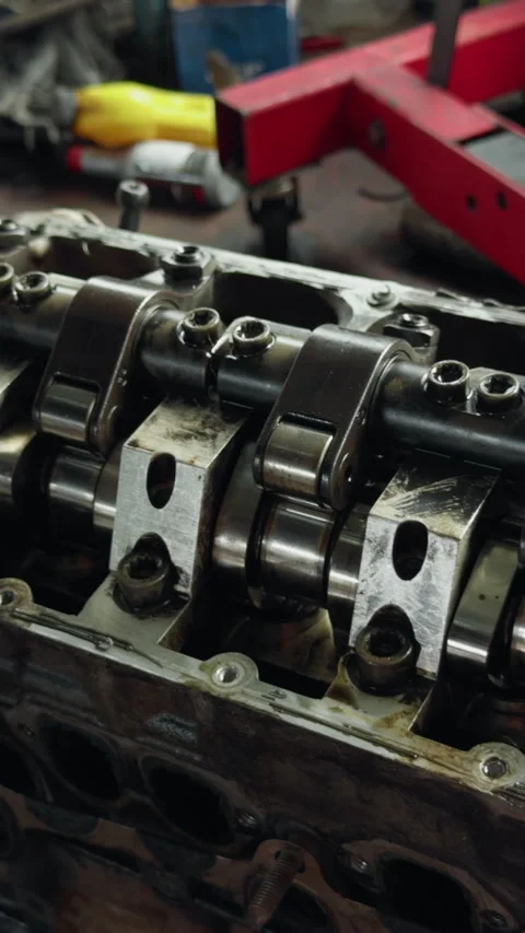 Close-up of engine valve train with camshaft, rocker arms, and polished metal Stock Footage 345765136