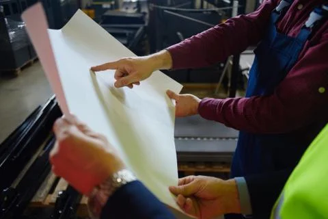 Close up. Engineer and foreman are discussing the new project at the factory Stock Photos