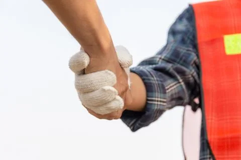 Close up of engineer and worker handshake with blurred construction site Stockfoto's