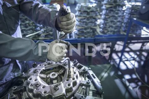 Close Up Of Engineer Assembling Industrial Clutch On Production Line