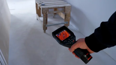 Close up. An engineer checks the heated floors with a thermal imager. Stock Footage 129070195