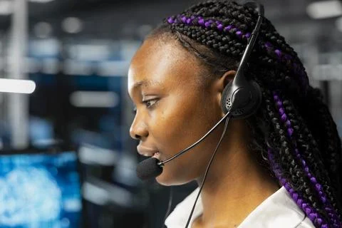 Close up of engineer in data center speaking in headset mic, doing tech support 스톡 사진