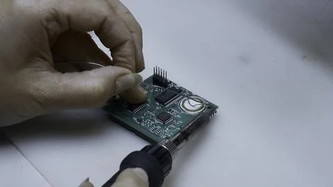 Close up of engineer does computer motherboard soldering. Creative. Painstaking Stock Photos