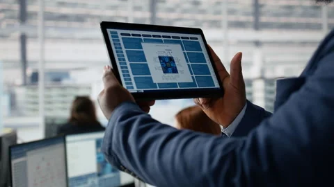 Close up of engineer examining microchip circuit layouts on tablet in factory Stock Footage 335882364