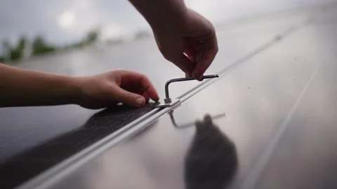 Close-up of an engineer hammering a bolt while installing a solar panel. Stock Footage 313234801