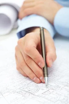 Close-up of engineer hand with pen over blueprint with sketches of projects Fotos de archivo