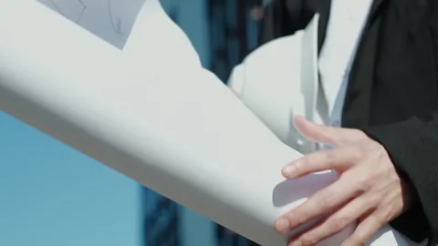 Close-up of an engineer holding a construction helmet against the backdrop of a Stock Footage 249263009