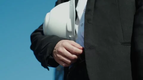 Close-up of an engineer holding a construction helmet against the backdrop of a Vídeo Stock 249263018