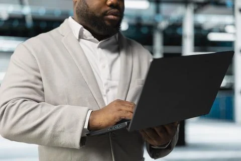 Close up of engineer in server hub checking recovery plan on laptop Stock-Fotos