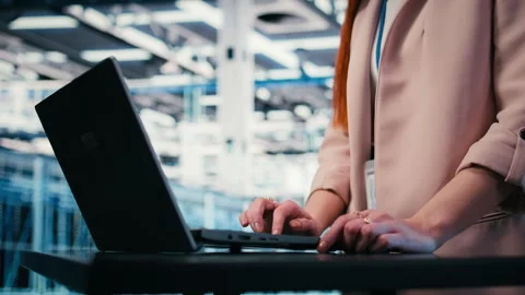 Close up of engineer typing on laptop in server farm Stock Footage 330031621