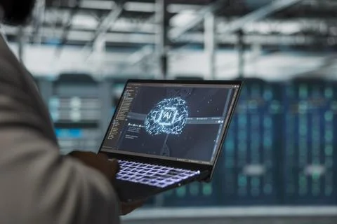 Close up of engineer using laptop in data center, doing complex AI calculations Stock Photos