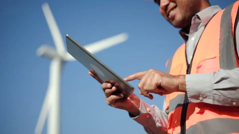 Close up engineer using tablet control wind turbines windmill energy farm. Stock Footage 222885544