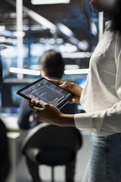 Close up of engineer using tablet in data center, updating neural networks 写真素材