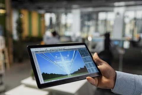 Close up of engineer using tablet to refine transmission tower systems 写真素材