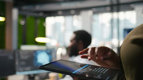 Close up of engineer using tablet to write code, developing machine learning API Stock Footage 313165507