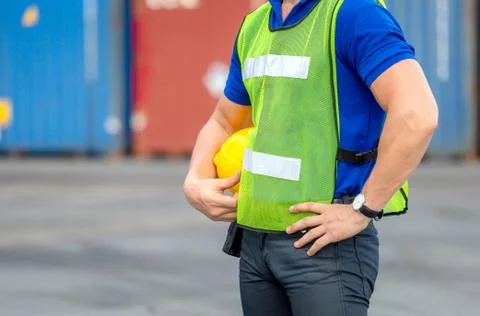 Close up of Engineer, worker man holding hard hat at cargo containers 写真素材