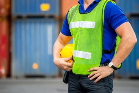 Close up of Engineer, worker man holding hard hat at cargo containers Фото