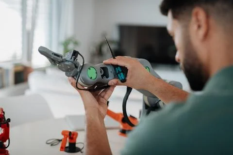 Close up of engineers hands building and programming a robotic arm at home. Foto stock