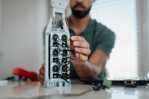 Close up of engineers hands building and programming a robotic hand at home. Fotos de archivo