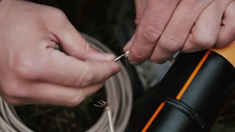 A close-up of an engineers hands connecting two wires with a connector. Stock Footage 318268473