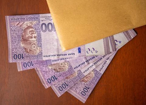 Close up of an envelope filled with documents or contracts with money under it. Stock Photos