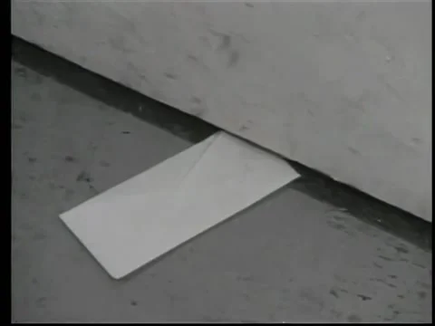 Close-up of envelope sliding under door Stock Footage 260240397