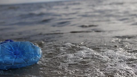 Close-up. Environmental pollution. A plastic bottle floats on the seashore. 4K Stock-Footage 117800033