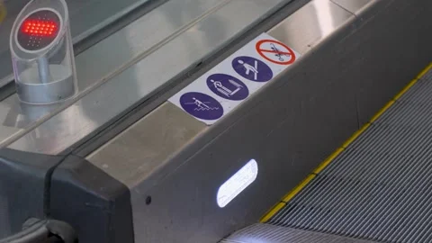 Close-up of Escalator Exit with Safety Warnings Stock Footage 308362618