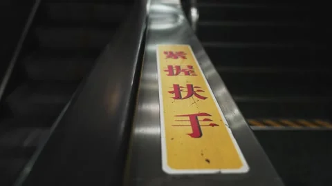 Close Up of Escalator Step Safety Warning Sticker with red Chinese characters in Vídeo Stock 340304156