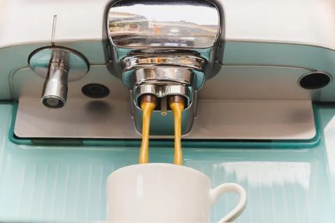 Close up of espresso coffe machine dispensing coffee into a coffee cup. Stock Photos