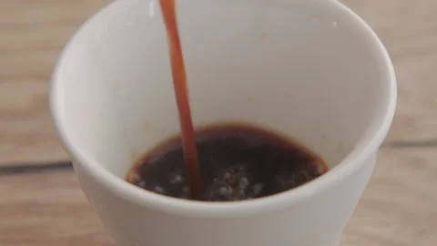 Close-up of espresso coffee poured in a small white cup Stock Footage 250833282