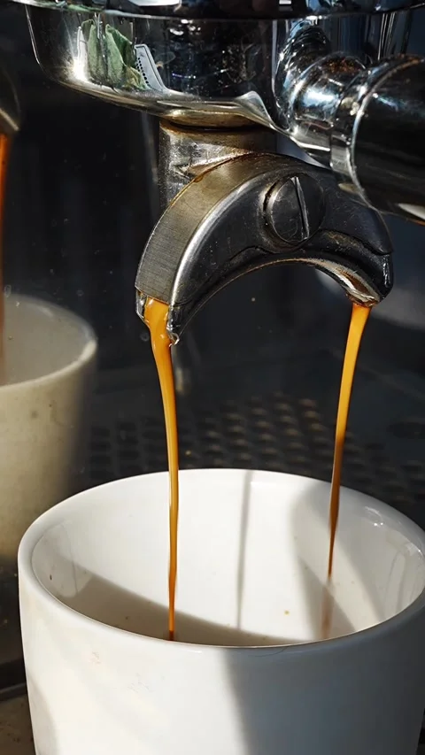 Close-up of espresso machine pouring coffee into a white cup Stock Footage 345538855